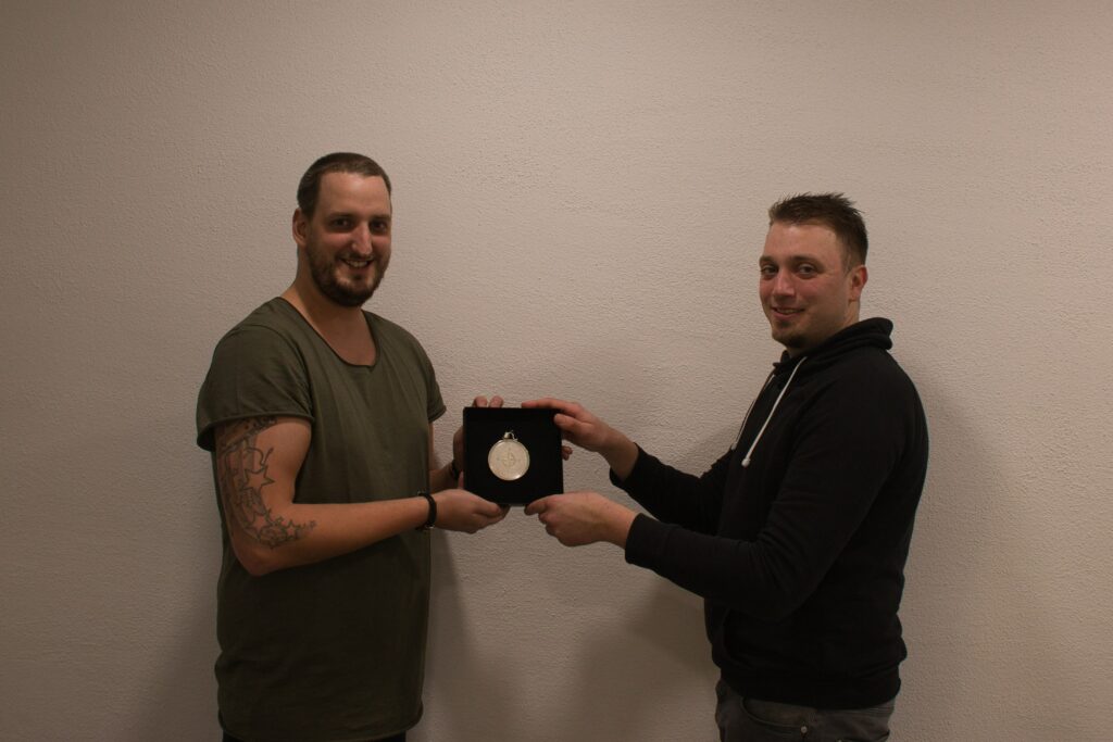 Die Abbildung zeigt links Michael Thym und rechts Matthis Reichstein. Beide halten die Schachtel mit dem Königsorden 2019.